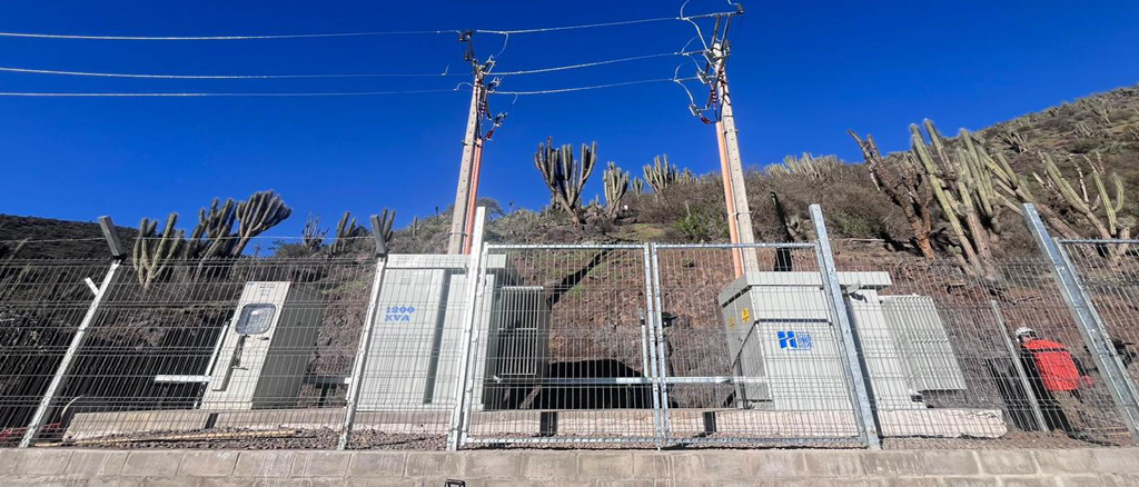 Subestación eléctrica en paisaje desértico con transformadores y cactus.