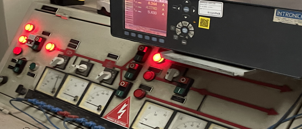Tablero de control eléctrico con luces y pantalla digital de corriente.